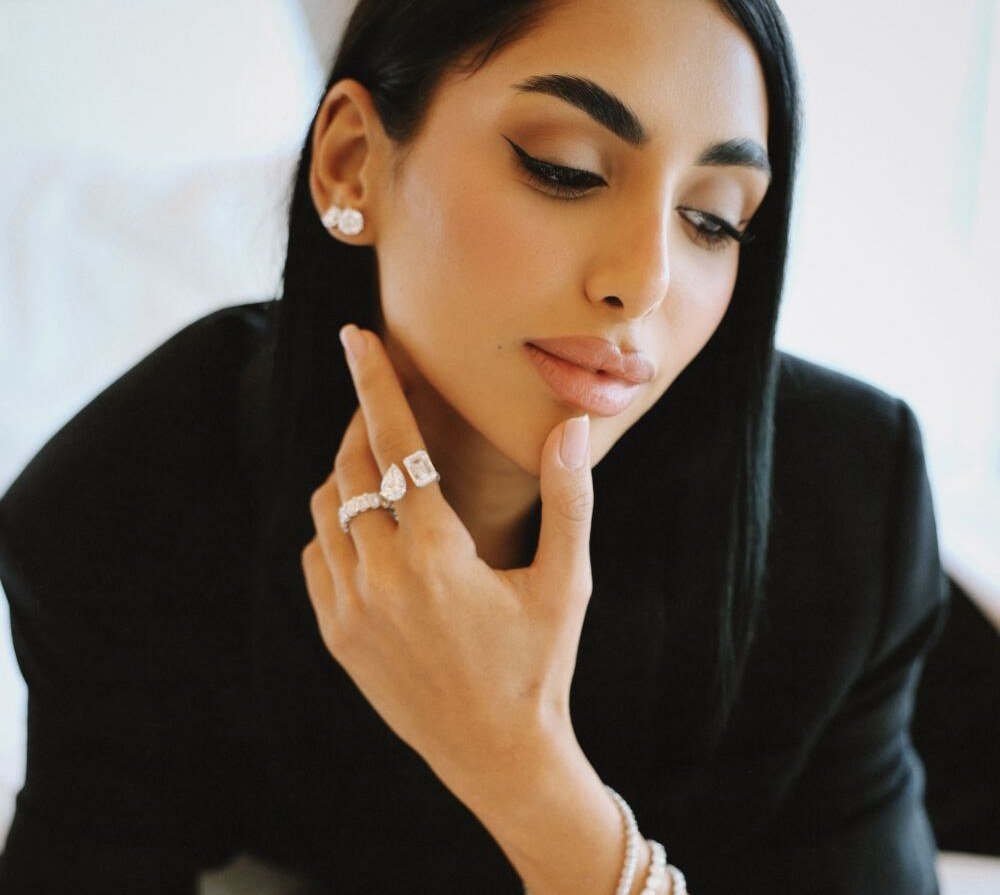 Diamond toi-et-moi ring and studs worn with a hand at the chin