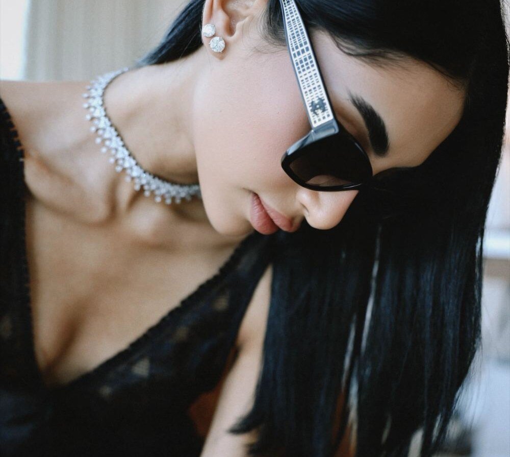 Diamond studs and fringe choker worn with cat-eye sunglasses