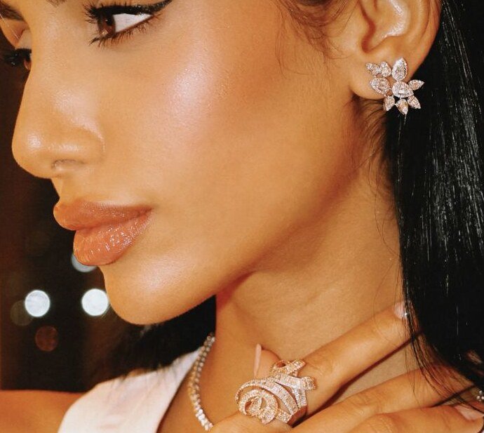 Diamond flower earring and spiral ring close-up at the collarbone