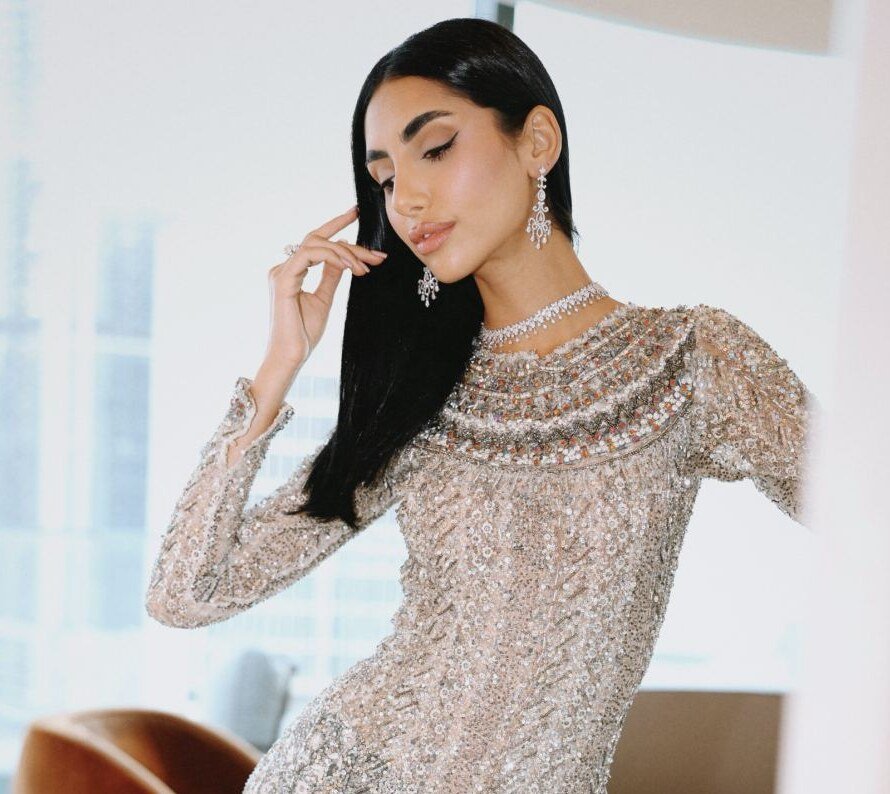 Model leaning in a sequinned gown with diamond choker and chandelier earrings